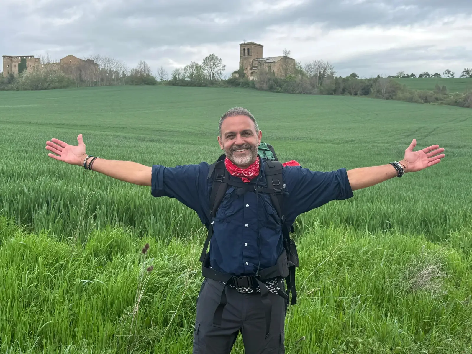 Alejandro Pérez Bolaños with open arms in a green field