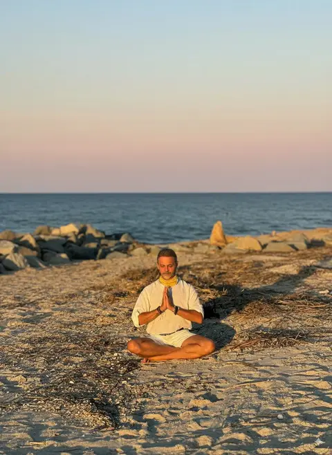 Alejandro Pérez Bolaños meditating on the beach, conveying peace