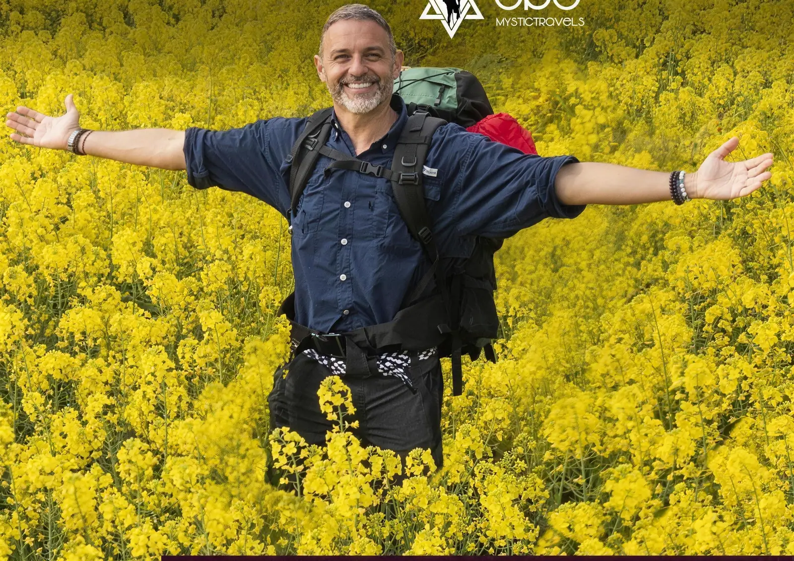Alejandro con los brazos abiertos en un campo de colza amarillo